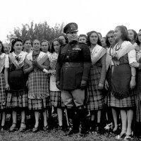Il Duce nella campagna parmense tra donne in abiti tradizionali, visita di Mussolini a Parma per la consegna della “Spiga d’oro”, 8/10/1941, Archivio fotografico Amoretti